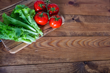 Flat lay. Kitchen table with lettuce and red tomatoes. Copy space