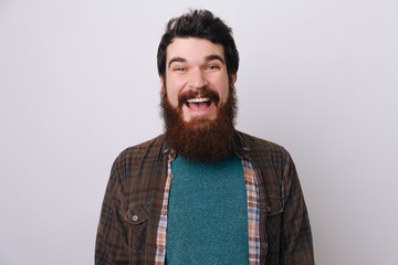 Happy young unshaven male in casual clothes has good mood. Emotive bearded man