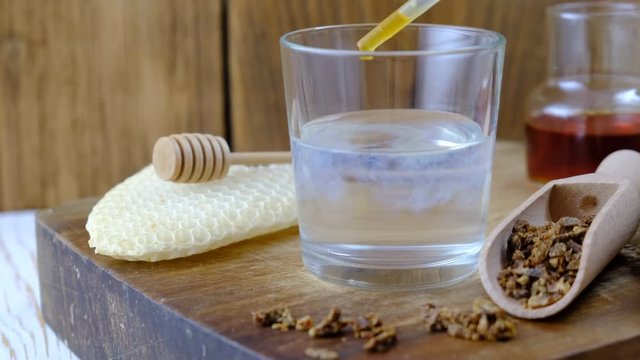 Treatment with propolis tincture. A bottle of propolis tincture and a wooden scoop of propolis granules. Medical preparations bee propolis. Apitherapy. Bee glue.