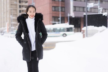 Beautiful young asian woman smiling happy for travel in snow winter season