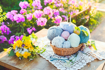 Women's hobby. Knitting and knitting needdles on the wood table in the garden on a Sunny summer day.	
