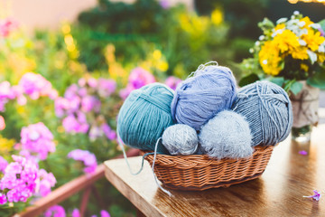 Women's hobby. Knitting and knitting needdles on the wood table in the garden on a Sunny summer day.	