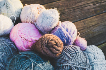 Fototapeta na wymiar Women's hobby. Colorful skeins of yarn on wooden old background.