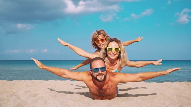 Father, mother and child against blue sea and sky background