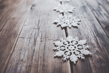 Christmas decor. White snowflakes  on wooden background.