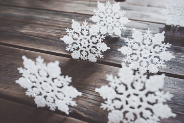 Christmas decor. White snowflakes on wooden background.	