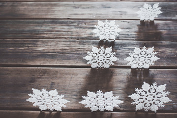 Christmas decor. White snowflakes  on wooden background.
