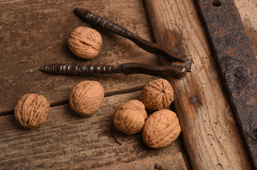 Walnut kernels and whole walnuts on rustic old oak table.