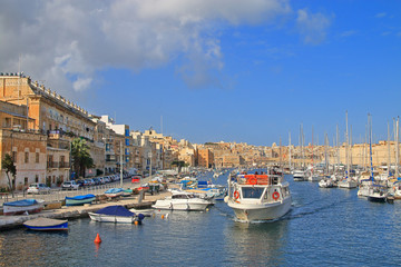 Motorboat cruise along the harbor of the island of Malta along moored yachts and boats.