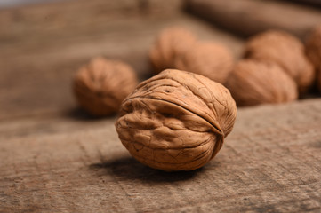 Walnut kernels and whole walnuts on rustic old oak table.
