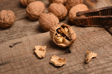 Walnut kernels and whole walnuts on rustic old oak table.