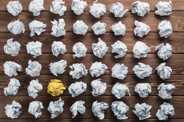 Concept of creativity and inspiration presented by many white paperballs and one color