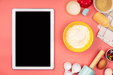 Baking ingredients with empty tablet on pink background, flat la