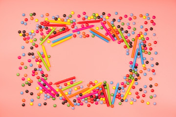 Colorful sprinkles  and birthday candles on pink background