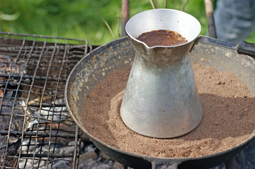 turkish coffee in cezve prepared on a pan with hot sand