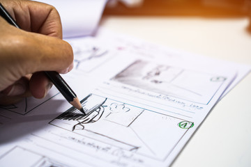 Hands on Storyboard movie layout for pre-production, storytelling drawing creative for process production media films. Script video editors and writing graphic in form displayed in maker shooting