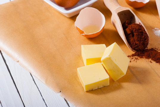 Cocoa Powder And Blocks Of Butter, Cake Ingredients On Baking Paper