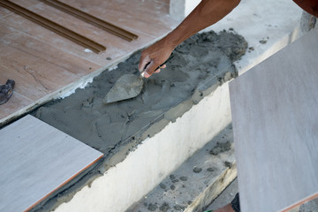 Construction worker with plaster knife for floor renovation.