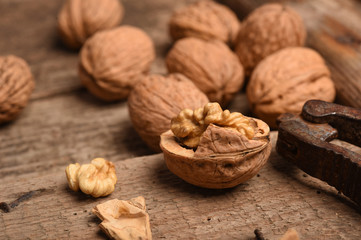Walnut kernels and whole walnuts on rustic old oak table.