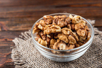 Walnut on dark wooden background.