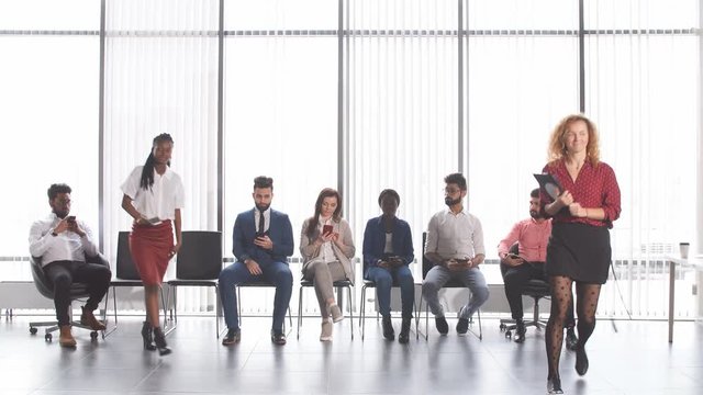 Recruits waiting for interviews for employment. Group of young businessman waiting for the start of reception sitting on chairs in lobby of an office building