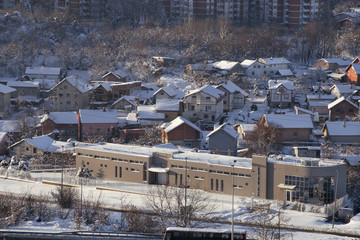 Fototapeta na wymiar Beautiful winter view of houses and buildings with roofs covered with heavy snow. In snowy season, roof with lot snow because of snow drifting, big snow layer. Winter day, weather, seasons specific.