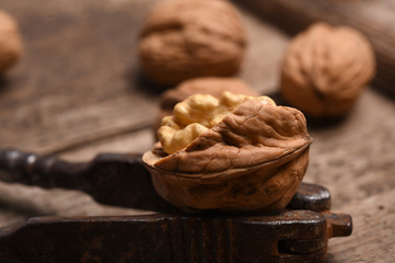 Walnut kernels and whole walnuts on rustic old oak table.