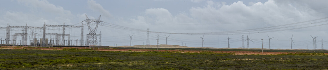 Fototapeta premium Windmills and electric trellis on a field near Atins, Brazil