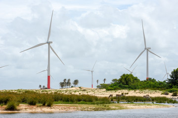 Fototapeta na wymiar Windmills on the sand dunes of Lencois Maranhenses near Atins, Brazil