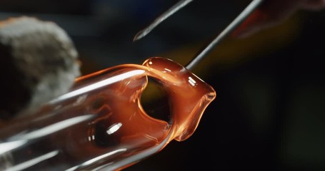 Slow motion macro of glass blower working with flame on a handmade art piece of glass from precious crystal in a workshop. Shot in 8K. Concept of handmade, quality, artisan, made in Italy, glass blow