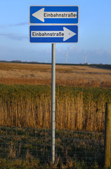 Schilder Einbahnstrasse weisen in unterschiedliche Richtungen (Neuharlingersiel in Ostfriesland)
