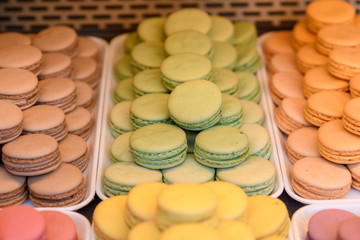 Pistachio, vanilla and caramel macaroons on display in a market store