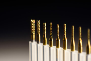 Metal cutting machine tool, shallow depth of field, cutters close-up, drill bit on the table