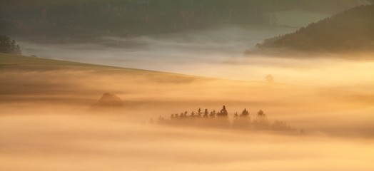 Sunset Over Misty Landscape Scenic View Of Foggy Morning Sky With Rising Sun Above dreamy Forest. Mountain range with visible silhouettes through the morning colorful fog  Beautiful background concept