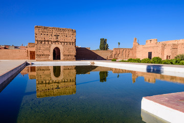 Sightseeing of Morocco. El Badi Palace in Marrakech medina with reflection in water pond. A popular architectural and tourist attraction.