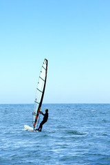 Windsurfer blue sky silhouette view. Freedom concept. Windsurfing background.