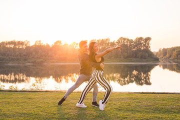 Kizomba, bachata, zouk and latin social dance concept - Man and woman dancing over nature background