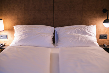 Bed maid-up with clean white pillows and bed sheets in beauty bedroom. Close-up. interior background