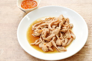 stewed duck intestine in brown soy soup on plate dipping spicy sauce