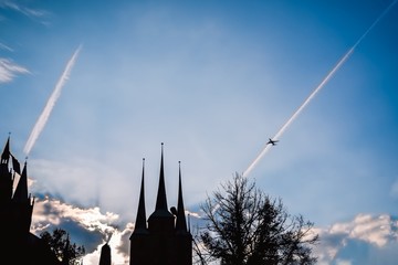 Famous Cathedral and Severi church in Erfurt, Germany. Silhouettes. Evening sky and airplane