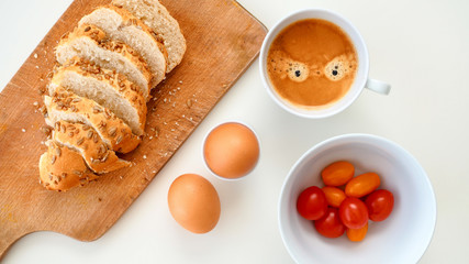 Pyszne i zdrowe śniadanie. Jajka, pocięta bułka, pomidorki i kawa