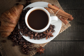 Coffee cup and beans on a rustic background. Coffee Espresso and a piece of cake with a curl. Cup of Coffee and coffee beans on table