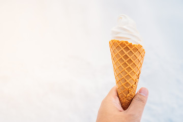 Hand holding ice cream with cone