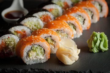 Maki rolls and nigiri sushi on a wooden table. Salmon, avocado and caviar rolls.