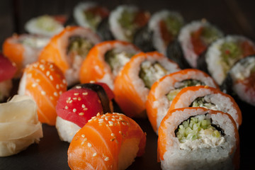Maki rolls and nigiri sushi on a wooden table. Salmon, avocado and caviar rolls.