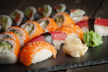 Maki rolls and nigiri sushi on a wooden table. Salmon, avocado and caviar rolls.