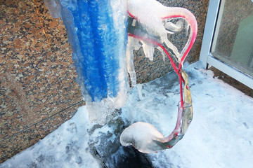Dangerous frozen electricity wires in tube covered with ice in winter. Heavy snow on electrical...