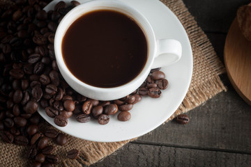 Coffee cup and beans on a rustic background. Coffee Espresso and a piece of cake with a curl. Cup of Coffee and coffee beans on table.