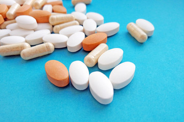 Pharmacy theme, health care, drug prescription for treatment medication and pharmaceutical medicament. Assorted colorful pharmaceutical medicine pills, tablets and capsules on blue background.
