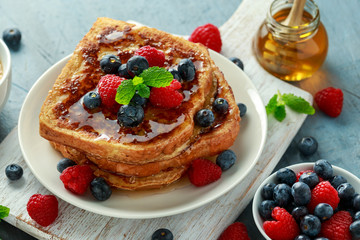 French cinnamon toast with blueberries, raspberries, maple syrup and coffee. morning breakfast